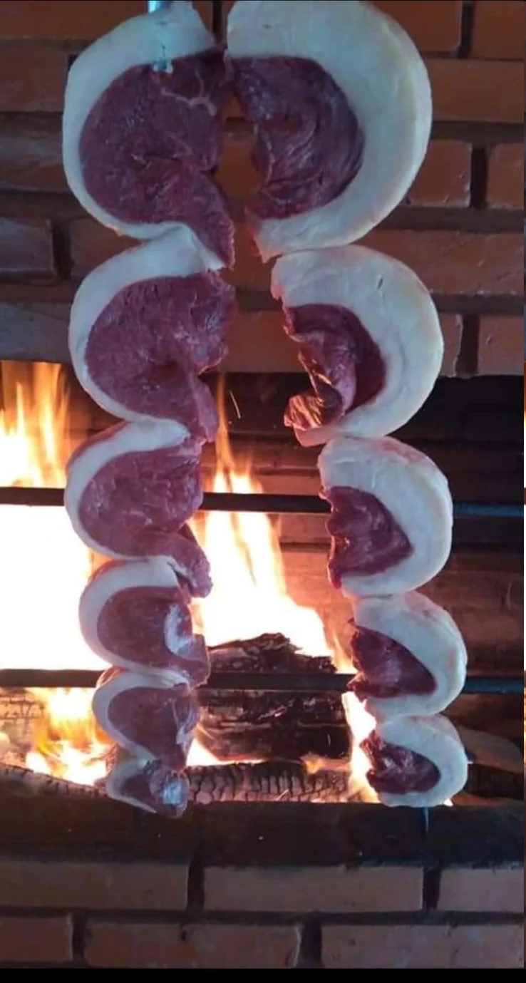 Espetos de picanha próximos ao fogo da churrasqueira