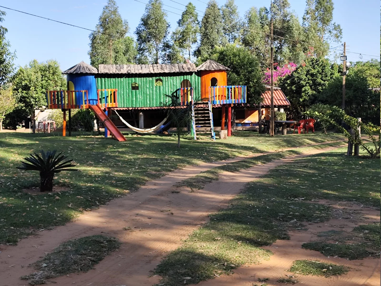 Casinha de madeira com escorregador na área kids