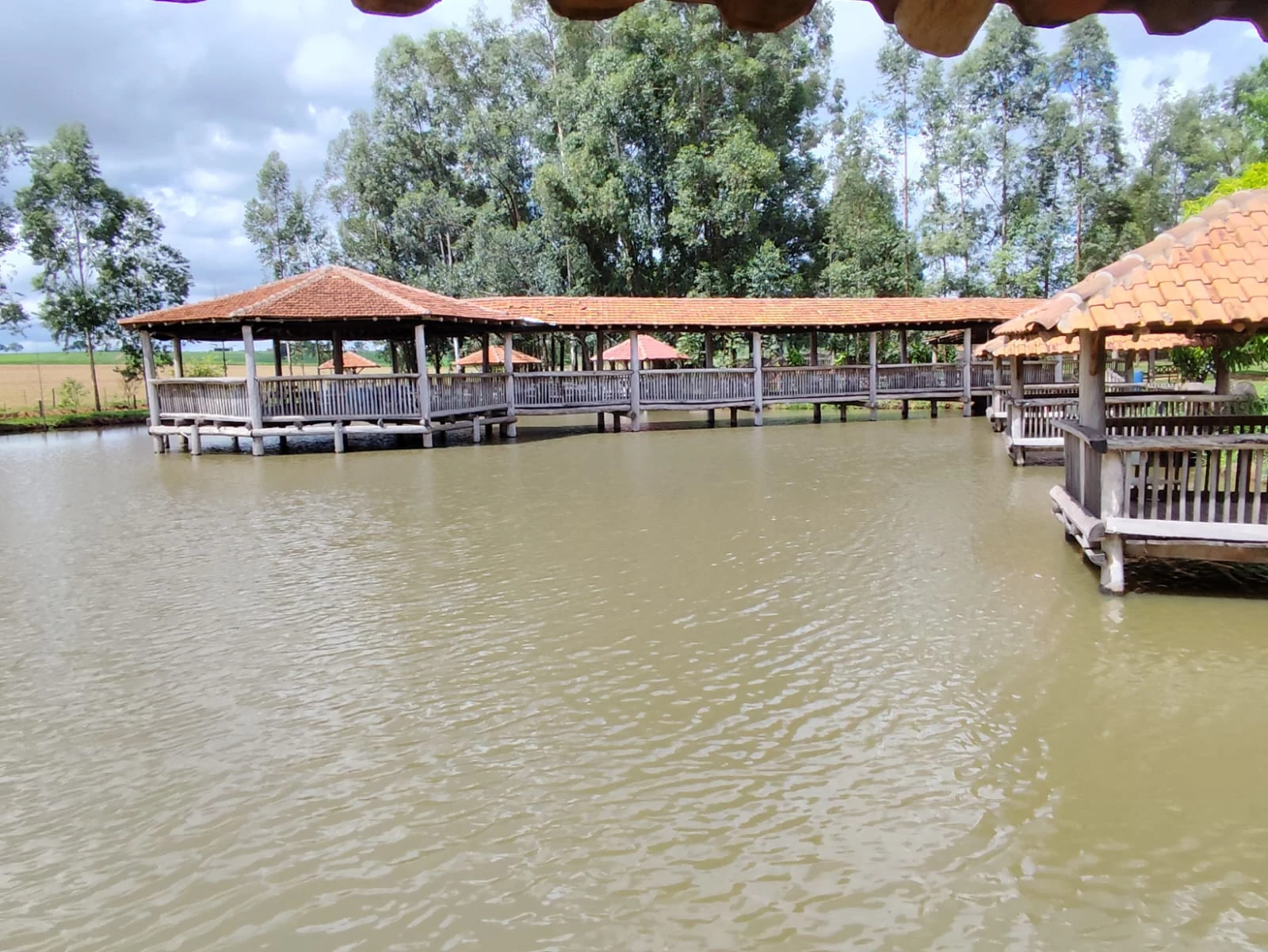 Lago com passarelas e quiosques cobertos do Pesqueiro Vitória