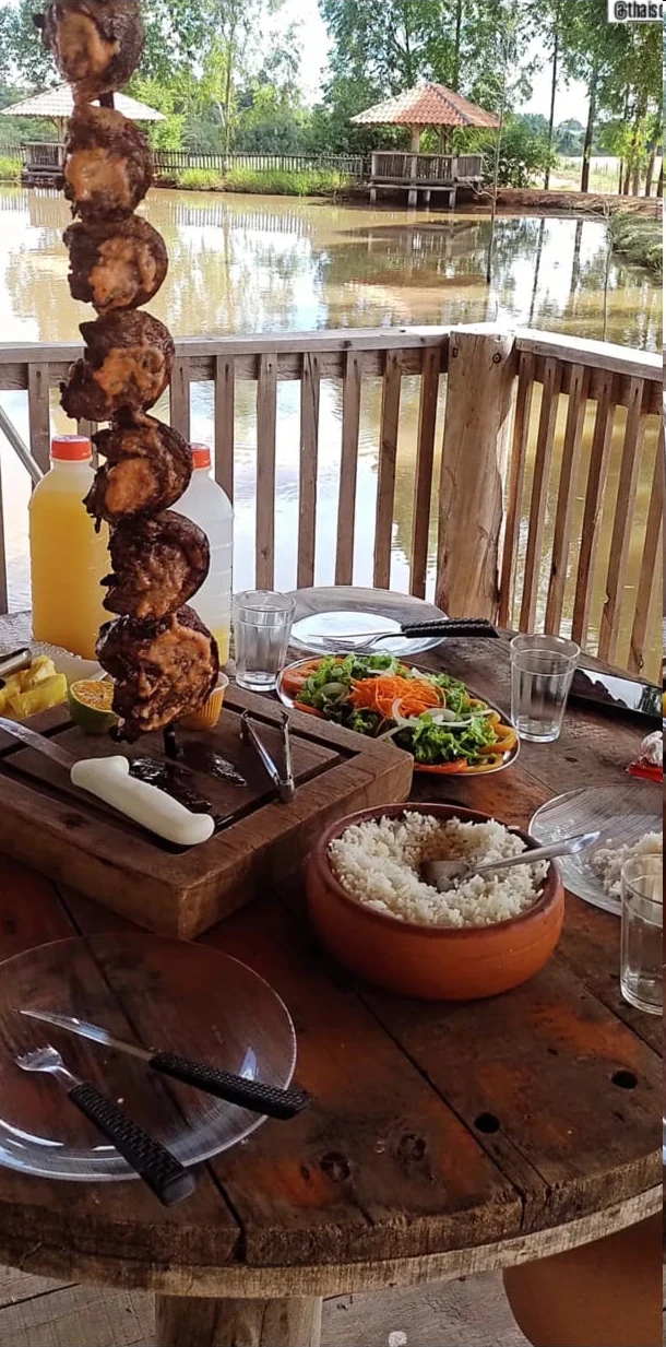 Picanha no espeto servida à mesa com arroz, salada e acompanhamentos