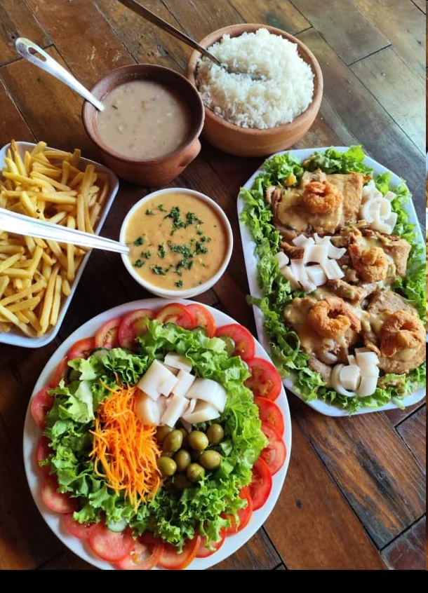 Filé de tilápia com camarão servido com arroz, fritas e salada
